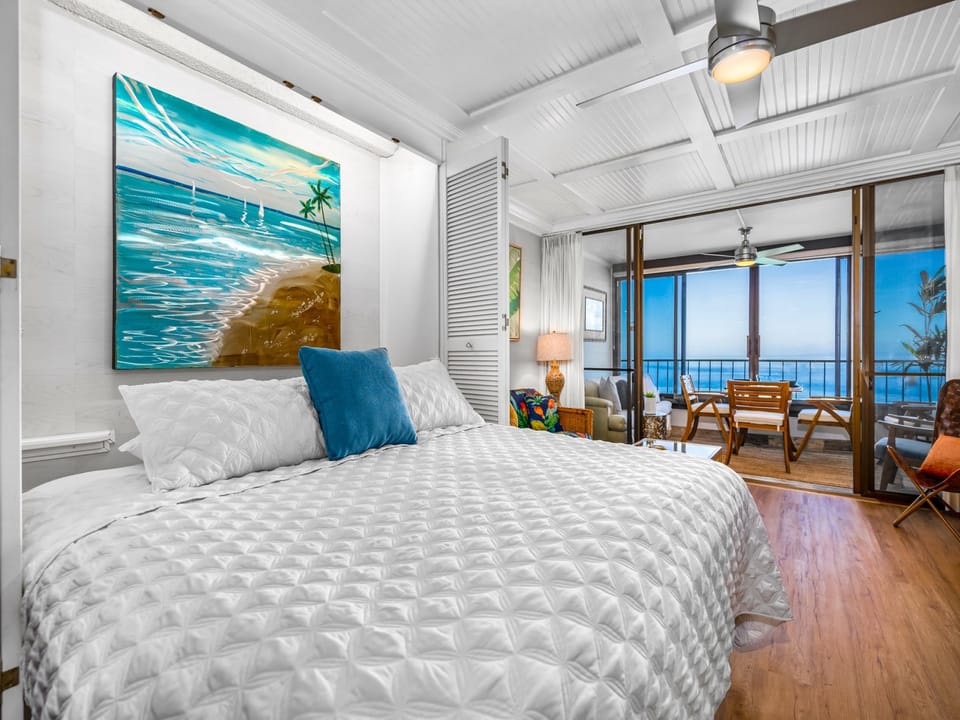 Wake to an ocean breeze in your bright coastal room, where soft white linens and warm wood floors set the stage for complete relaxation. Step through the sliding doors to your private balcony and greet endless blue horizons.