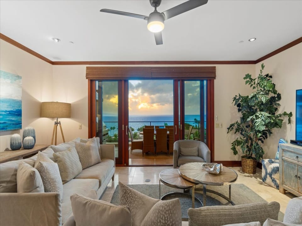 Step into a beautifully appointed living space where coastal elegance meets comfort. Sink into the plush sofa, watch the ceiling fan gently spin, and take in breathtaking ocean views through glass doors that open to your private terrace.