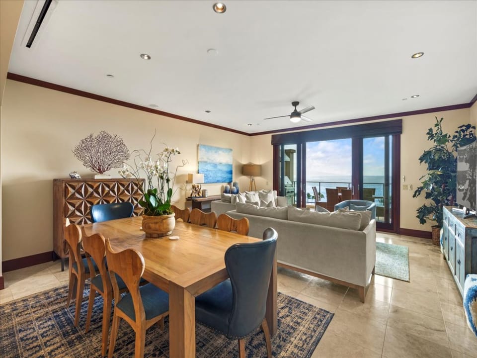 Your open-concept living and dining area welcomes you with warm coastal tones and breezy ocean views, where every corner invites relaxation and connection with the turquoise horizon.