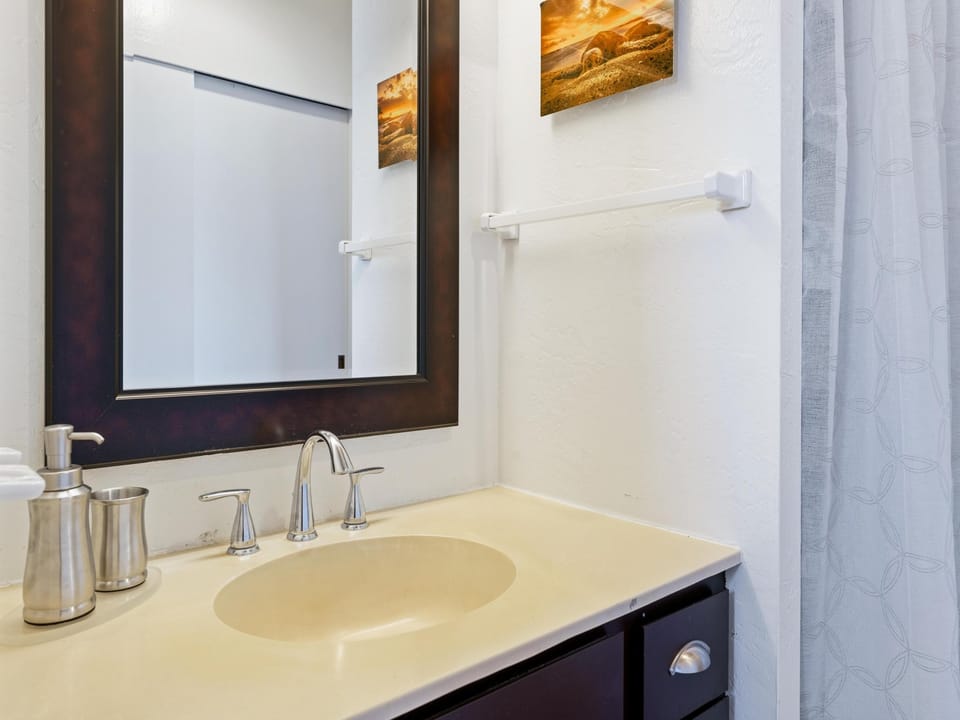 Freshen up in your private bathroom, complete with a polished vanity, soft towels, and coastal artwork that brings the beach right to your door.