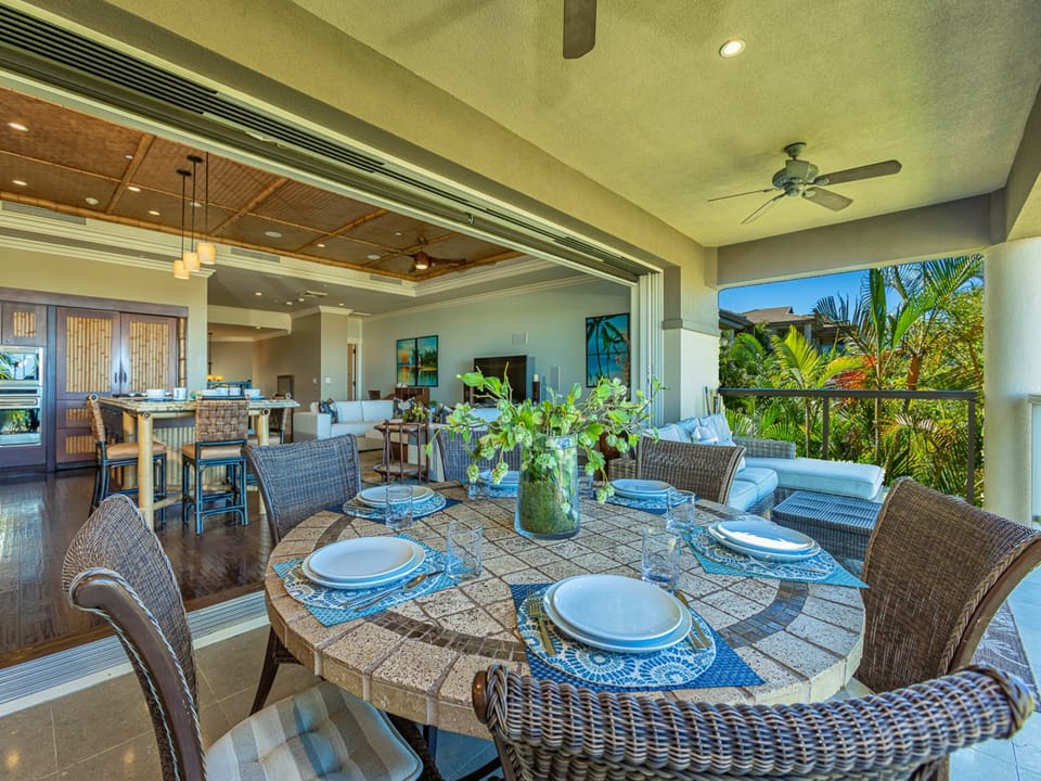 Picture yourself dining alfresco at this beautifully set outdoor table, surrounded by lush tropical greenery and cool ocean breezes. The seamless indoor-outdoor flow invites you to relax and savor every moment of island living.