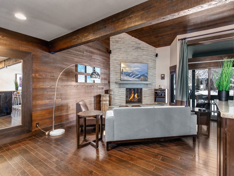 The open concept living room, dining and kitchen area with roaring fire and TV.