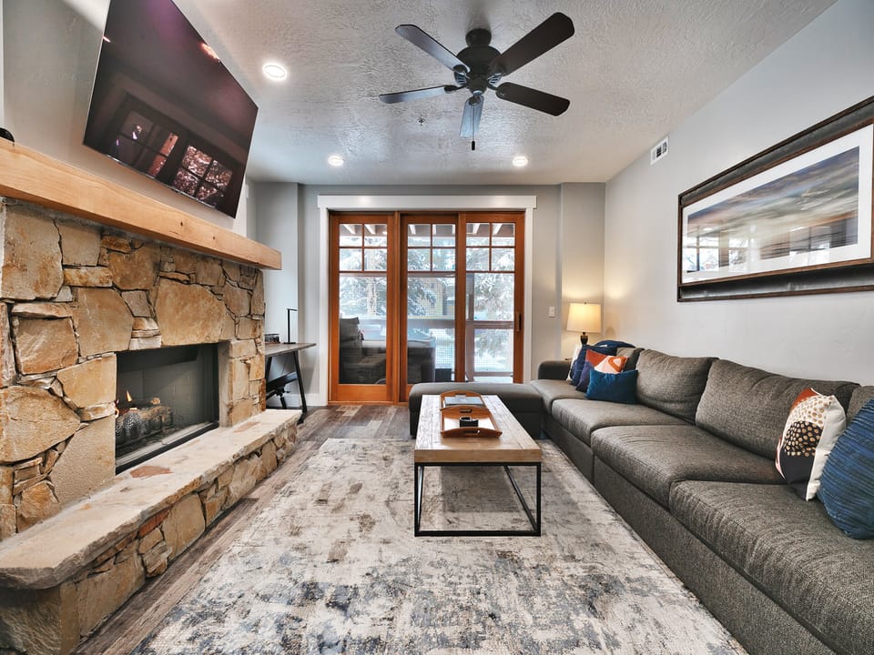 Spacious living room to gather around the gas fireplace with private deck access
