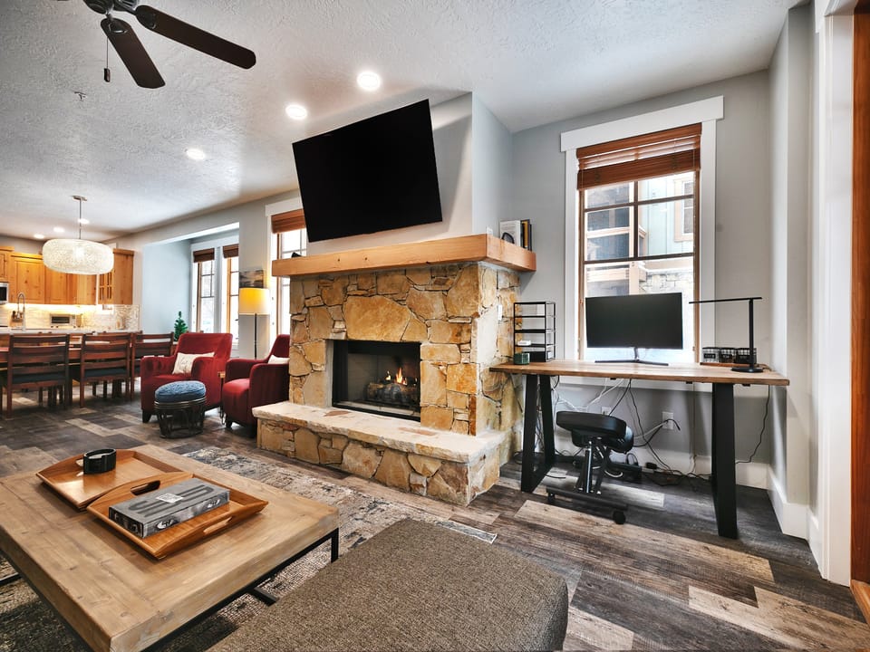 Work desk in the living room alongside the gas fireplace with wall mounted smart TV