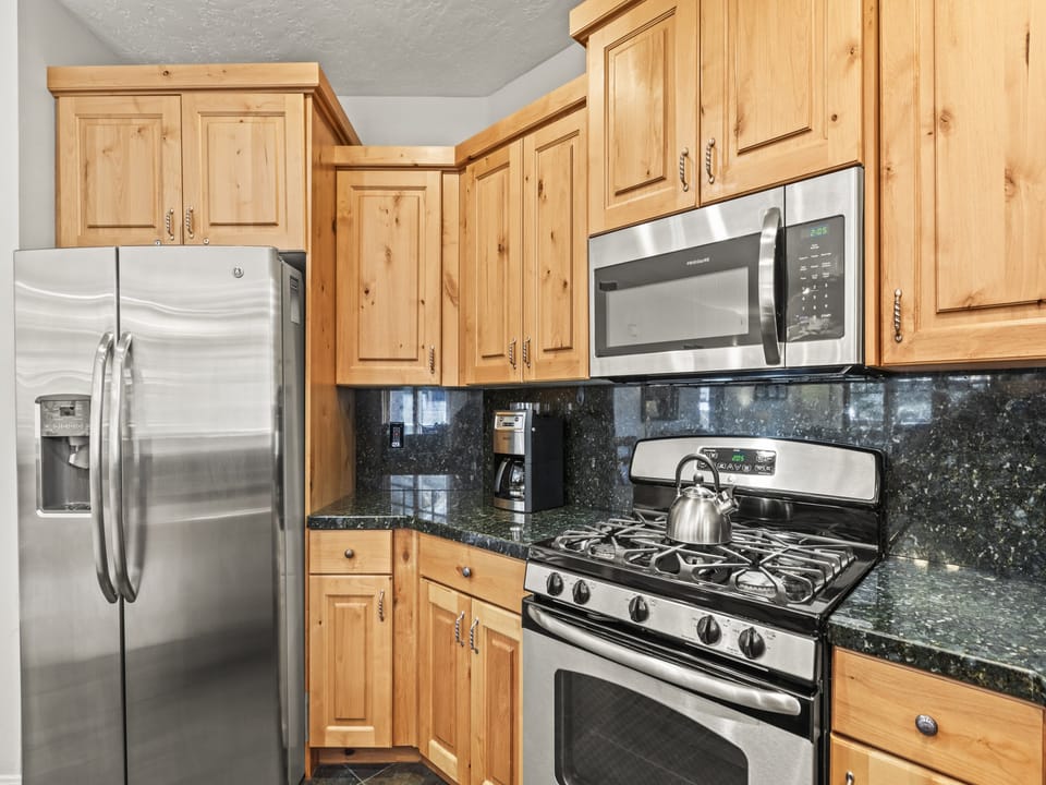 Town Pointe C101 has a well-equipped kitchen with stainless steel appliances and wood cabinetry.