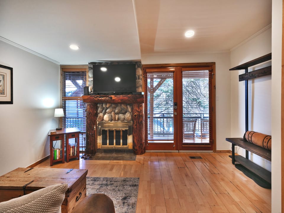 Glass doors for bright living area, river stone fireplace