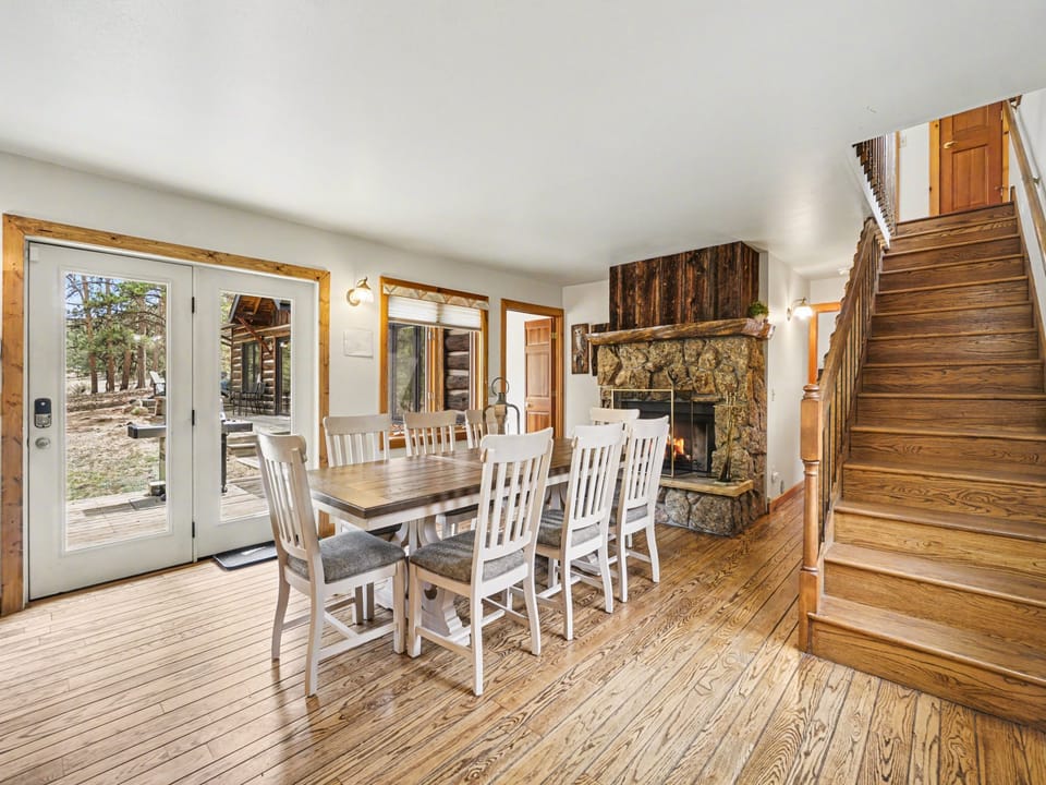 Gather around your rustic dining table where the stone fireplace creates a cozy atmosphere for memorable meals together.