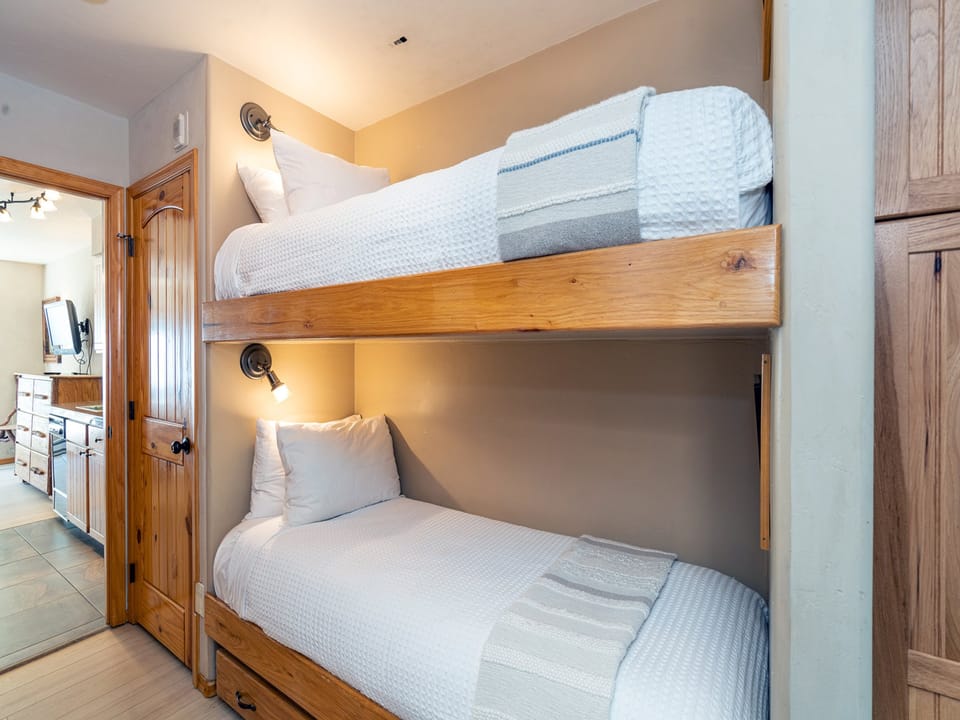 There are bunk beds in the hallway between the living room and main bedroom. Each bunk has it's own flat screen TV! Your kids will love you for this.