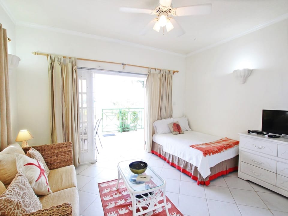 Double size bed and living area looking out to the patio