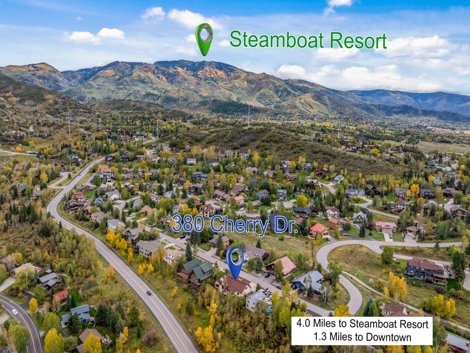 Aerial view showcasing Steamboat's vibrant autumn landscape with golden aspens framing a peaceful residential neighborhood beneath mountain peaks.