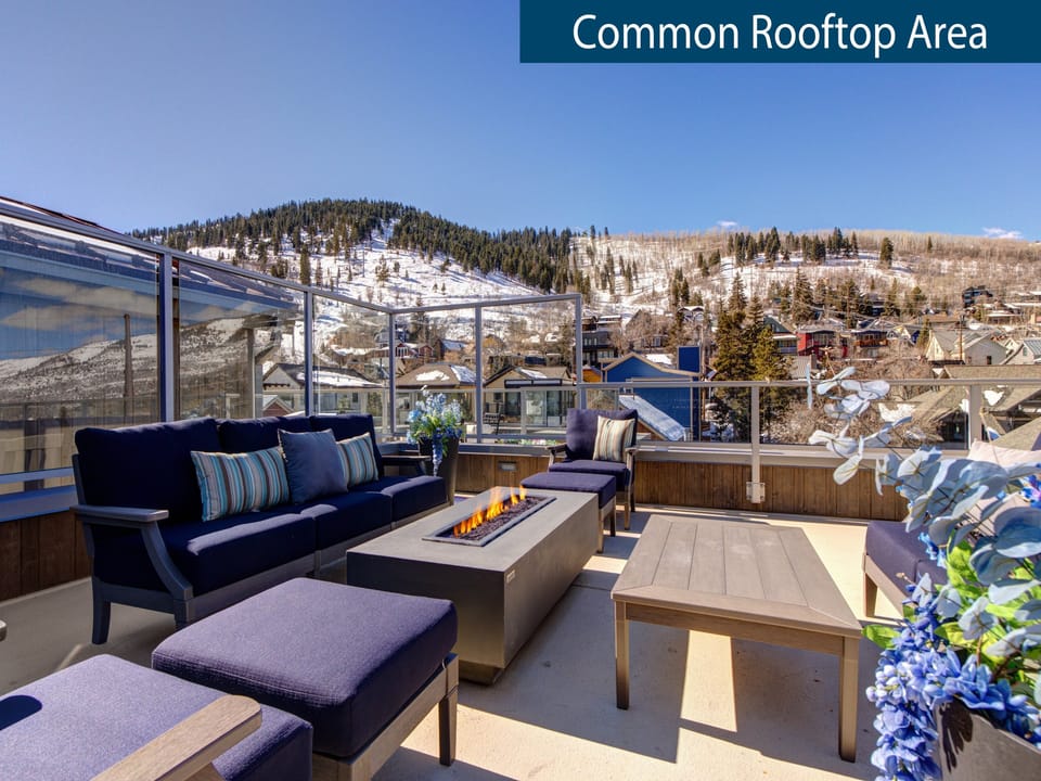 Rio Grande's rooftop sitting area with fire table overlooking snow covered mountains.