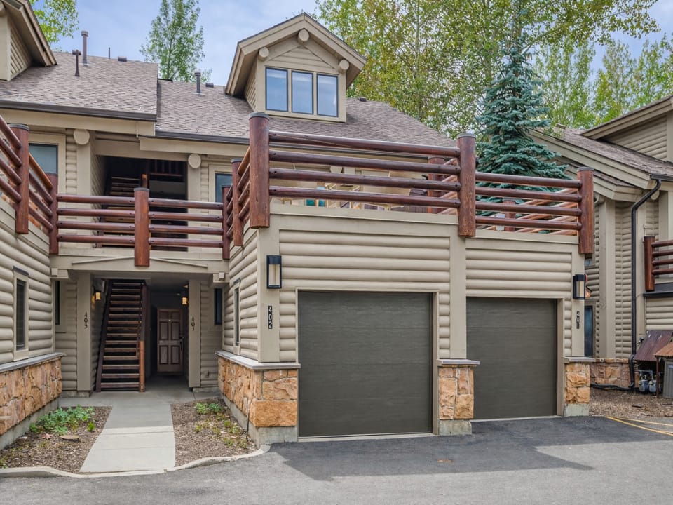 Modern townhome exterior featuring natural wood accents and mountain-style architecture with convenient garage parking.