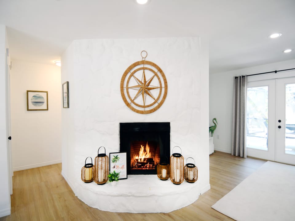 Cozy fireplace situated between the dinning room and living room area with patio and pool access