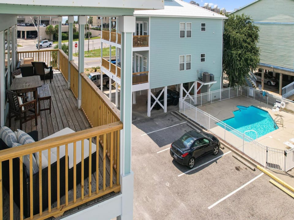 The spacious balcony offers plenty of seating and overlooks the communal pool.