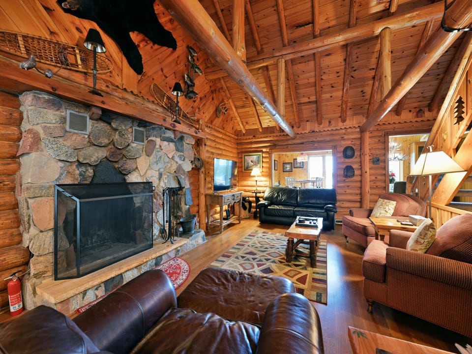 This main floor sitting room offers a rustic cabin feel with a flat screen to sit back and enjoy your favorite shows  or start  a fire in the fireplace to complete that "Northwoods" experience.