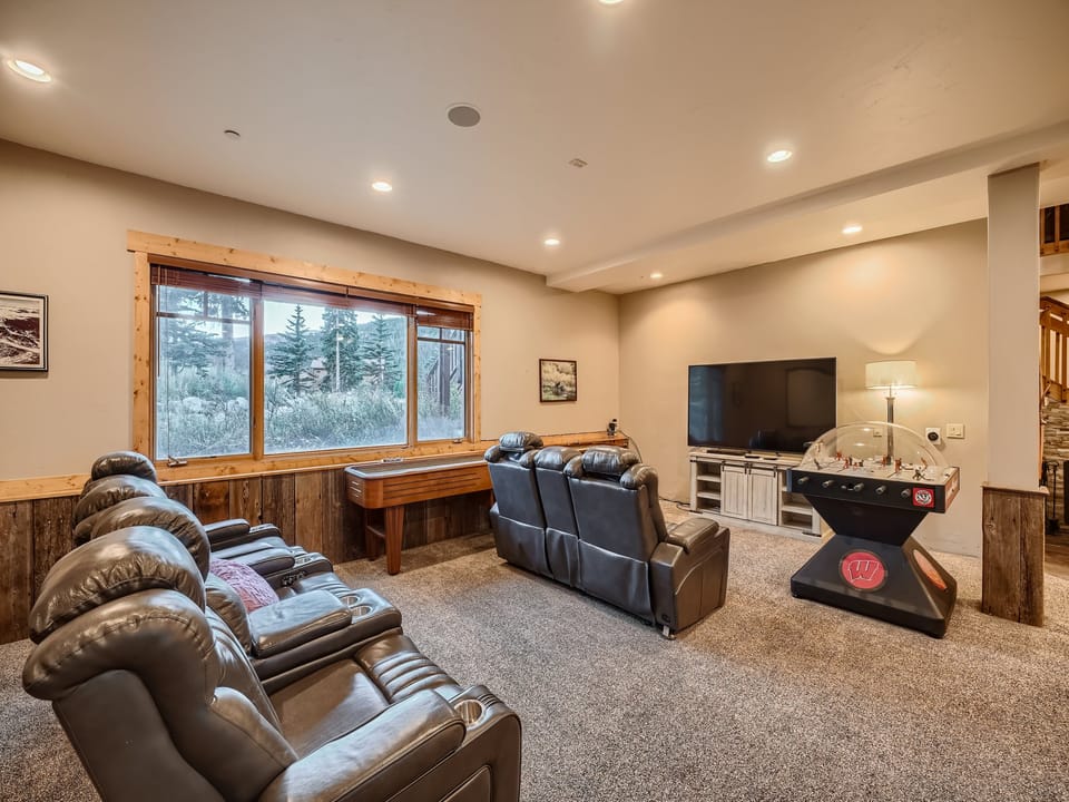 The huge garden-level game room features theater seating, a convertible pool/ping-pong table, Slapshot, and a wet bar.