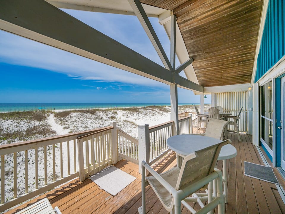 Enjoy a relaxing meal on the spacious deck with beach front views, featuring comfortable seating and a bright atmosphere
