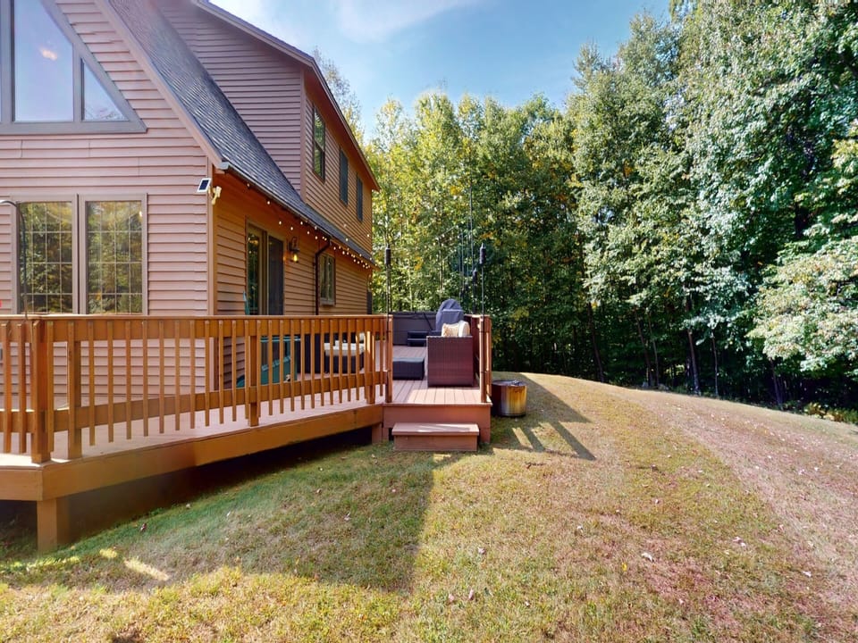 Back deck with outdoor hot tub and furniture.