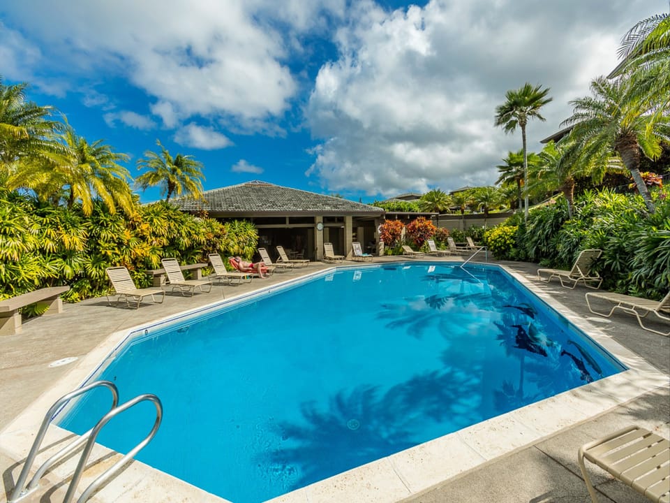 A sparkling blue pool awaits you, surrounded by swaying palms and vibrant tropical gardens. Lounge under sunny skies and enjoy your own slice of paradise.