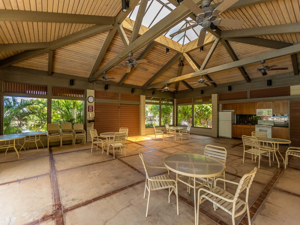 Step into a bright, open pavilion where tropical breezes and natural light flow freely. Round tables invite you to relax with your morning coffee or gather with friends, while the full kitchen stands ready for shared meals and laughter.