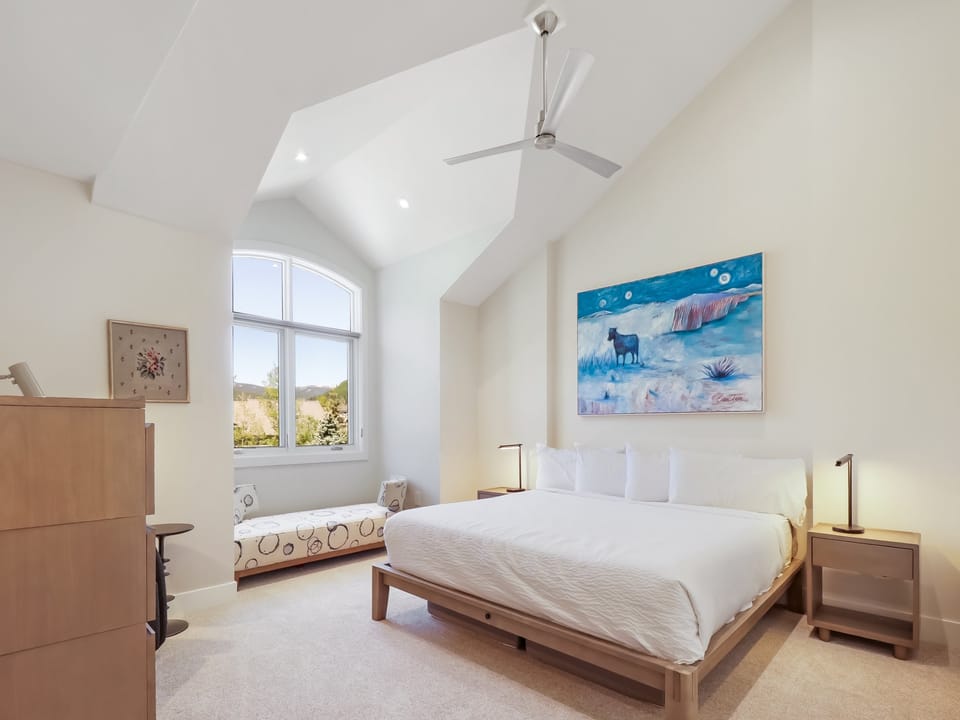 Your bright, spacious bedroom features a vaulted ceiling and sleek ceiling fan to keep you cool. Wake up to natural light streaming through arched windows with scenic views, and unwind in serene comfort.