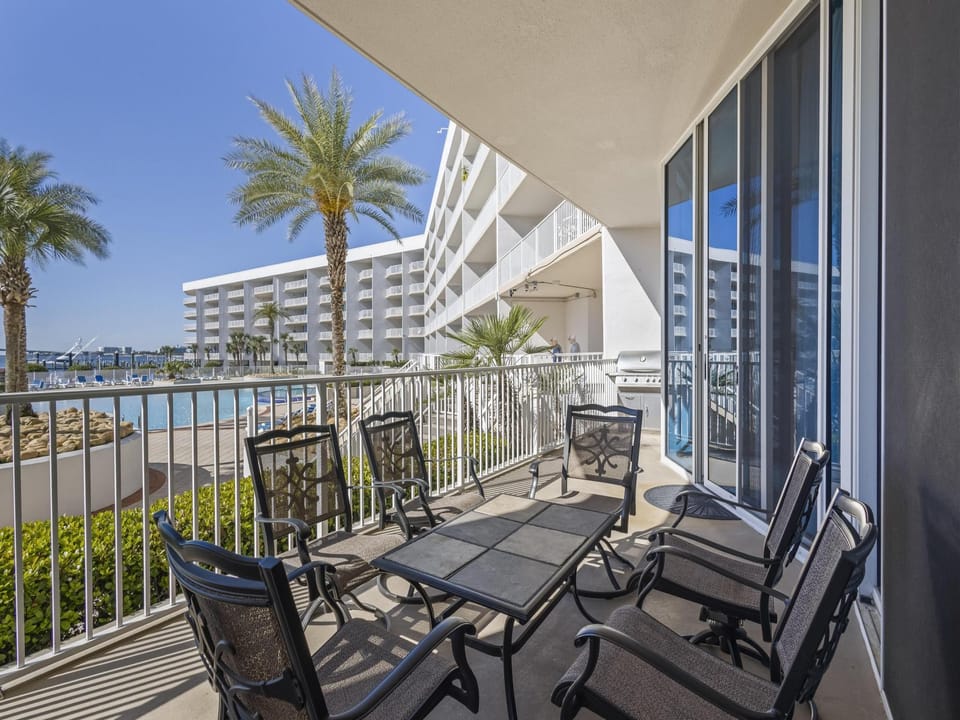 The spacious balcony features a table with seating for 6, and amazing views of the pool and bay!
