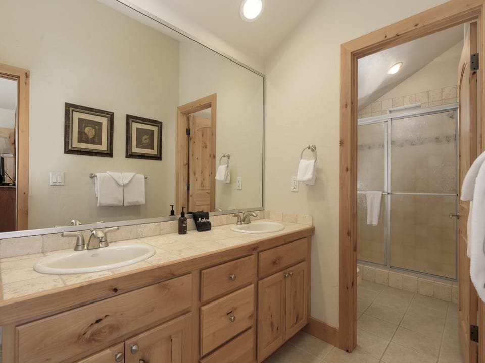 Double vanity with a spacious glassed in shower.