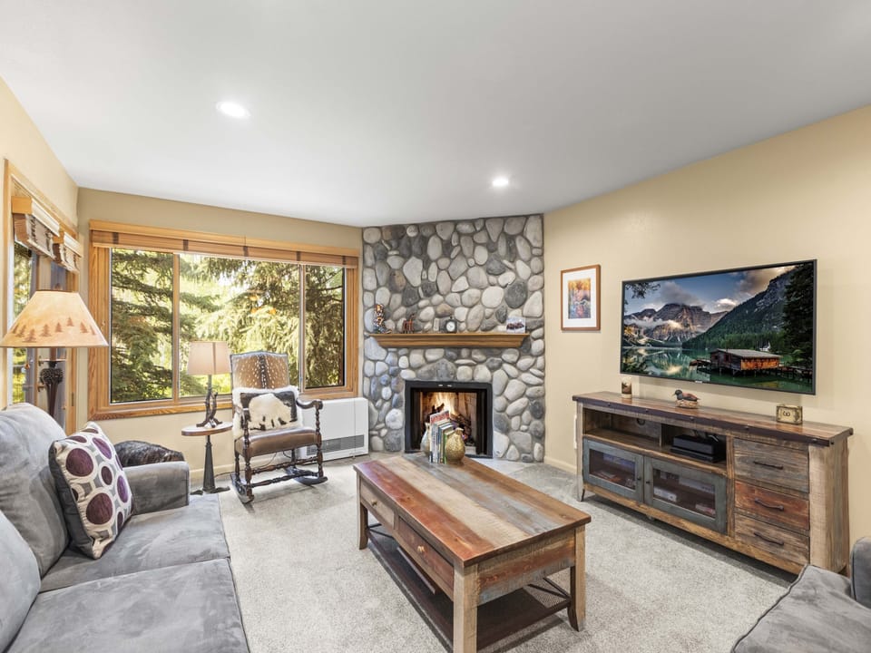 The warm and inviting living room with a river rock hearth and gas burning fireplace.
