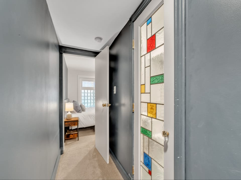 hallway looking toward bedroom, with beautiful bathroom door