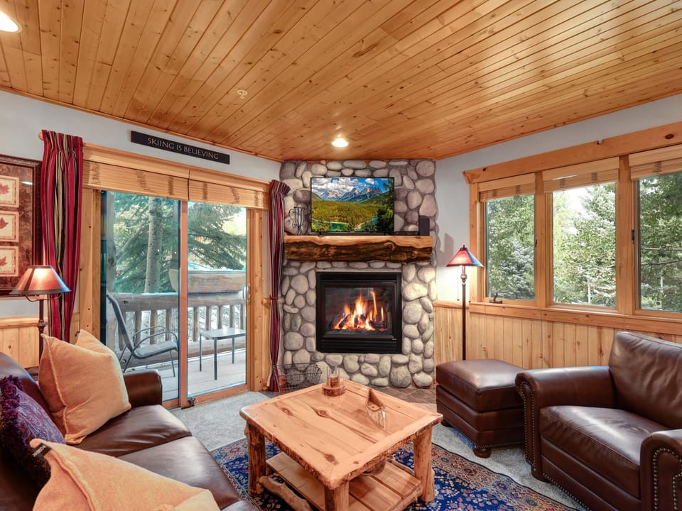 Timber Wolf Lodge 10 D has a cozy gas burning fire place and flat screen TV in the living room with leather couch and chair