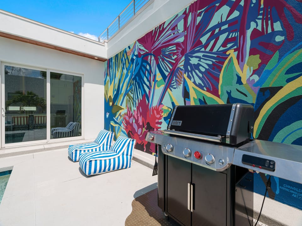 A vibrant tropical mural brings artistic flair to your private outdoor terrace, where you can fire up the grill and lounge in comfort under open skies.
