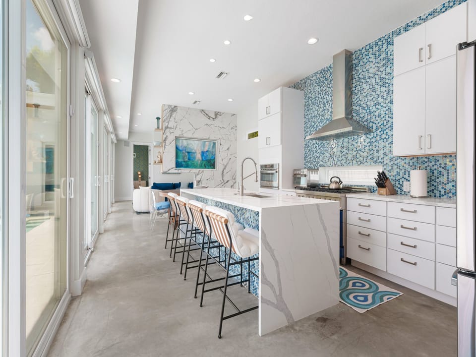 Discover your dream kitchen with a stunning turquoise mosaic backsplash, sleek marble waterfall island, and top-tier stainless appliances—perfect for cooking up memories during your stay.