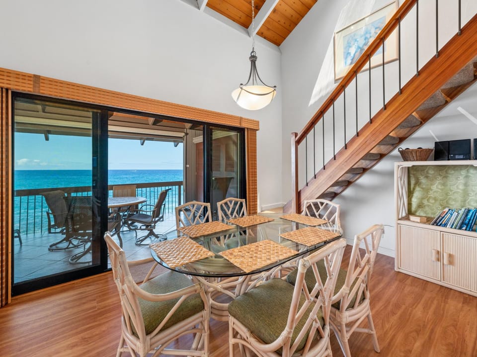 Dramatic vaulted ceilings and glass doors frame breathtaking ocean views in this coastal retreat. Dine at the island-inspired table while enjoying gentle breezes and endless blue horizons.