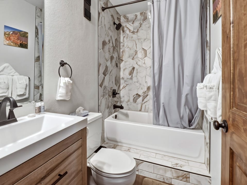 Unwind in your stylish bathroom with marble-accented shower, plush towels, and thoughtful amenities after your mountain adventures.