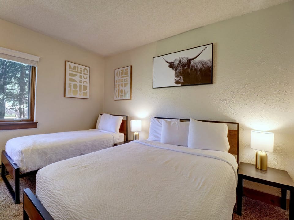 Twin bed and queen bed in hotel room.