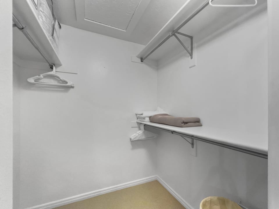 A spacious walk-in closet with convenient hanging rods and a built-in shelf to keep your wardrobe organized and within reach during your stay.