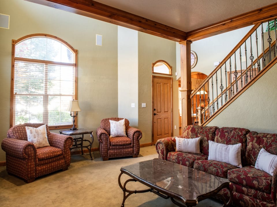 Large living room windows offer frame all the beauty the outdoors offer in this mountain escape.