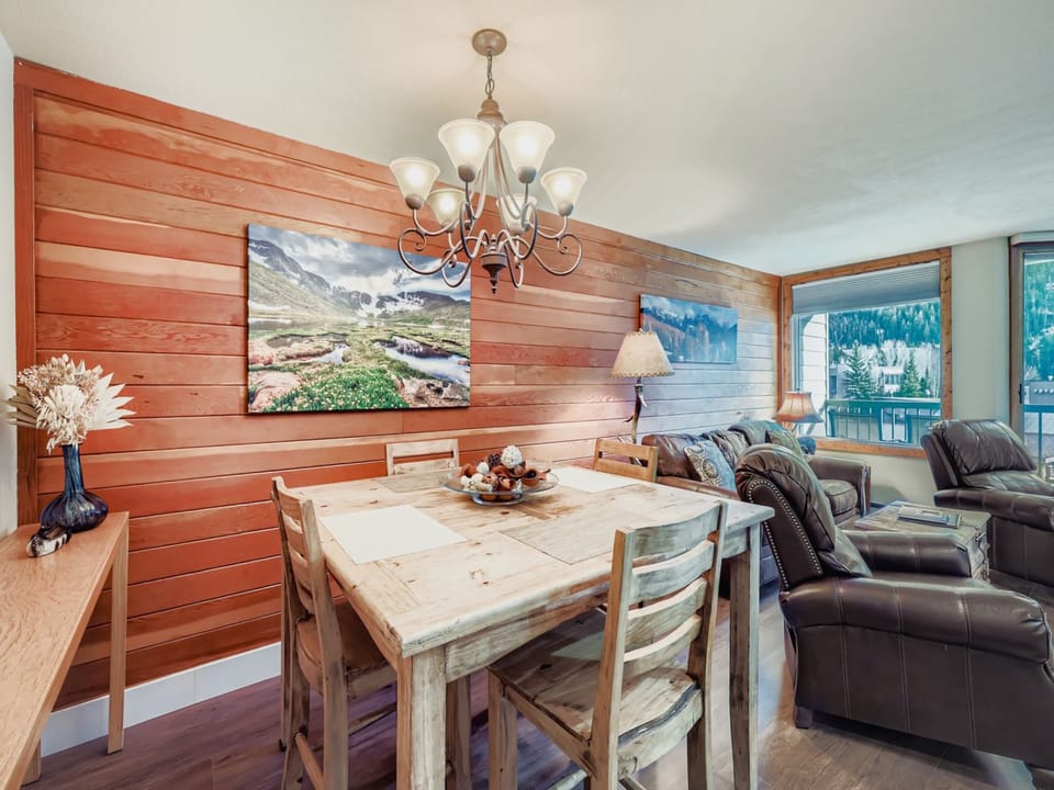 Relax in your cozy living and dining area featuring warm wood accents, comfortable leather seating, and rustic dining table perfect for memorable meals.