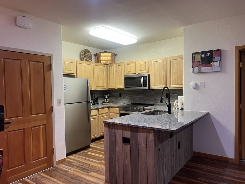 Your fully equipped kitchen awaits with granite countertops, stainless appliances, and a spacious island—perfect for preparing home-cooked meals and gathering with loved ones during your mountain getaway.