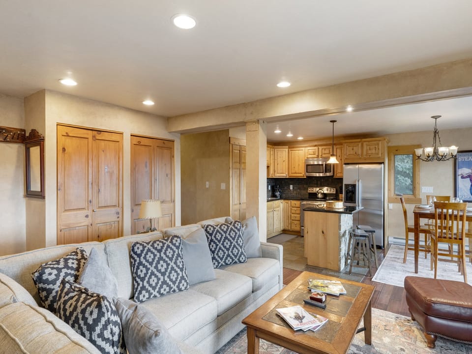 Photo taken from living room showing beige couch, looking into kitchen