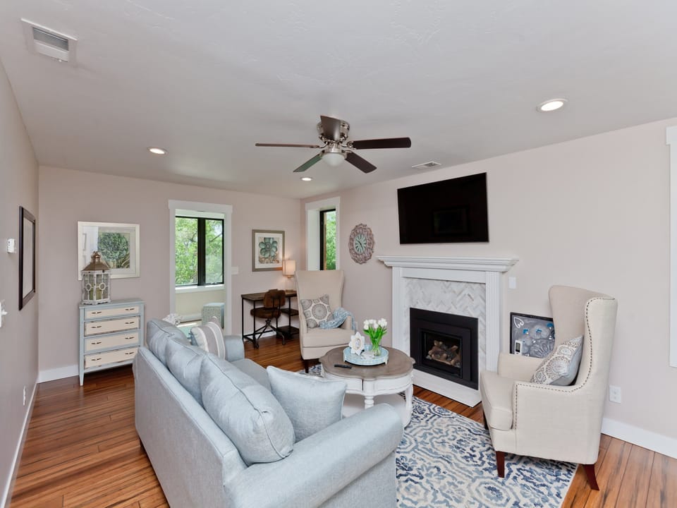 Relaxing living area with gas fireplace, smart TV, desk, printer and docking station for remote work