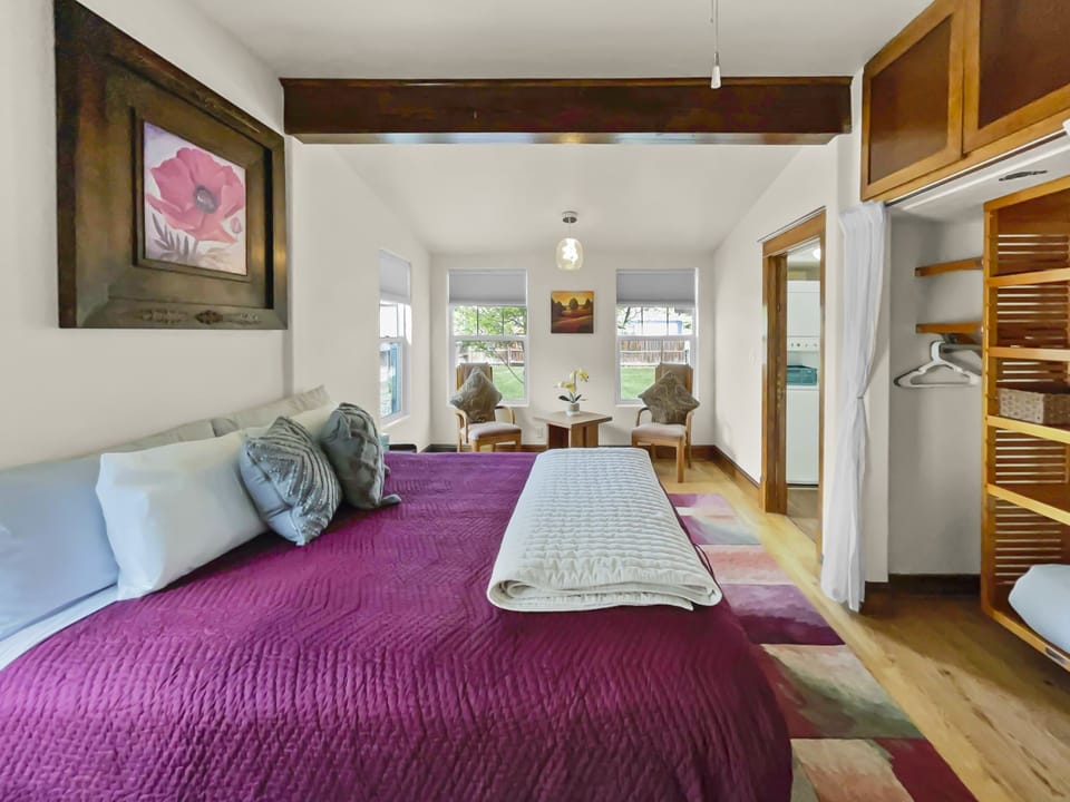 Primary bedroom with comfy king bed, vanity area, and nomad workspace.
