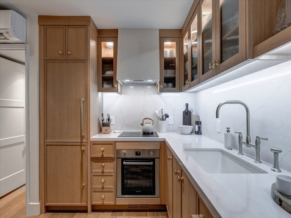 Blue Church Lodge G offers an open concept kitchen with custom cabinetry, stainless steel appliances and brass finishes.