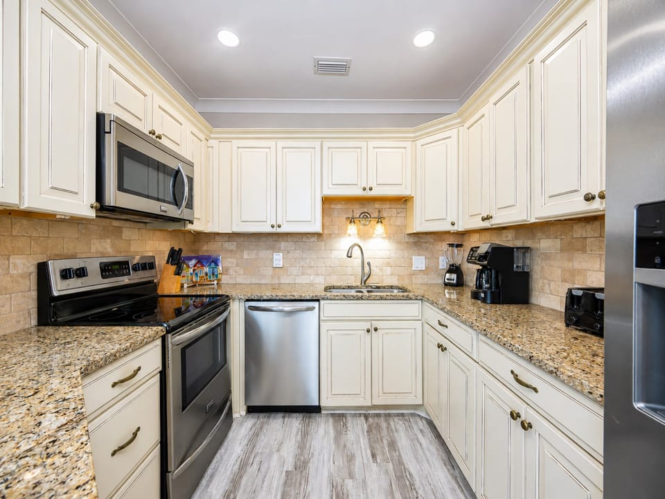 Cook and gather in this stylish kitchen featuring granite countertops, stainless appliances, and a cozy seating area