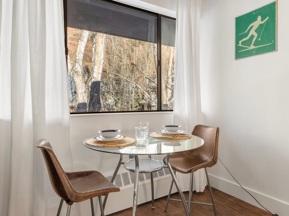 This unit Features a dining area for two with views of the local neighborhood.
