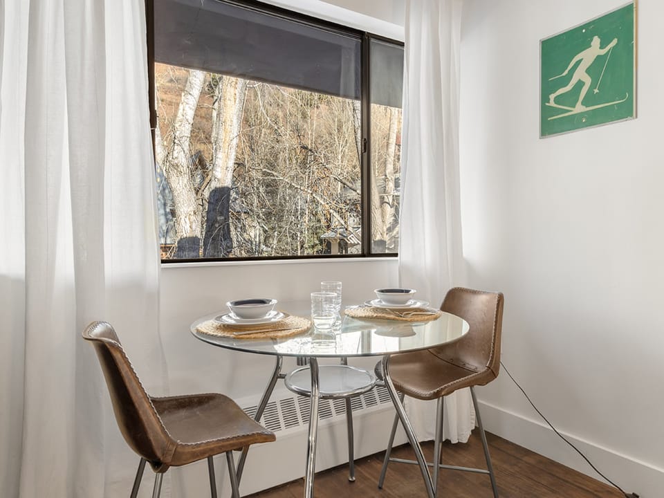 This unit Features a dining area for two with views of the local neighborhood.