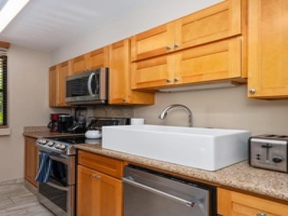 Your fully equipped kitchen features modern appliances, generous counter space, and warm wood cabinetry—perfect for preparing meals during your stay.