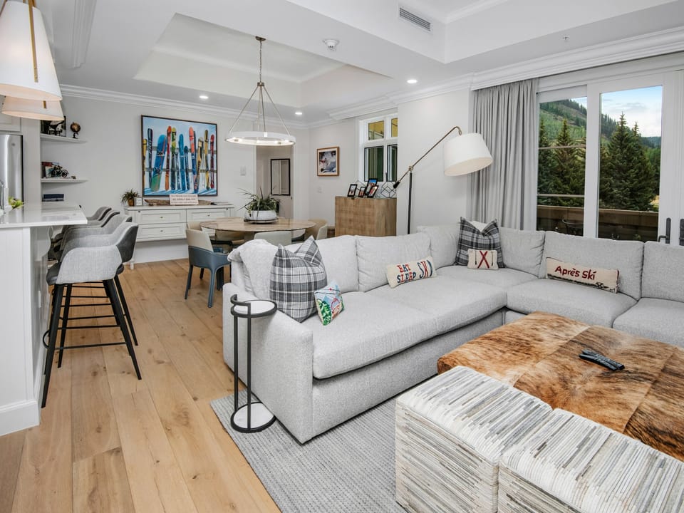 Unwind in your light-filled retreat with mountain views. Sink into the plush sectional or gather around the dining table—this open-concept space is where your après-ski memories unfold.