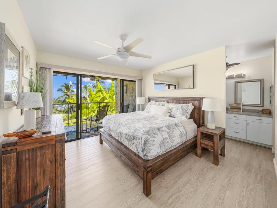 Drift off under the soft whir of the ceiling fan in this serene bedroom with coastal-inspired linens and warm wood accents. Your peaceful retreat awaits.