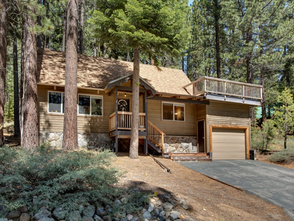 Charming cabin exterior surrounded by towering pines, offering a peaceful and private retreat.